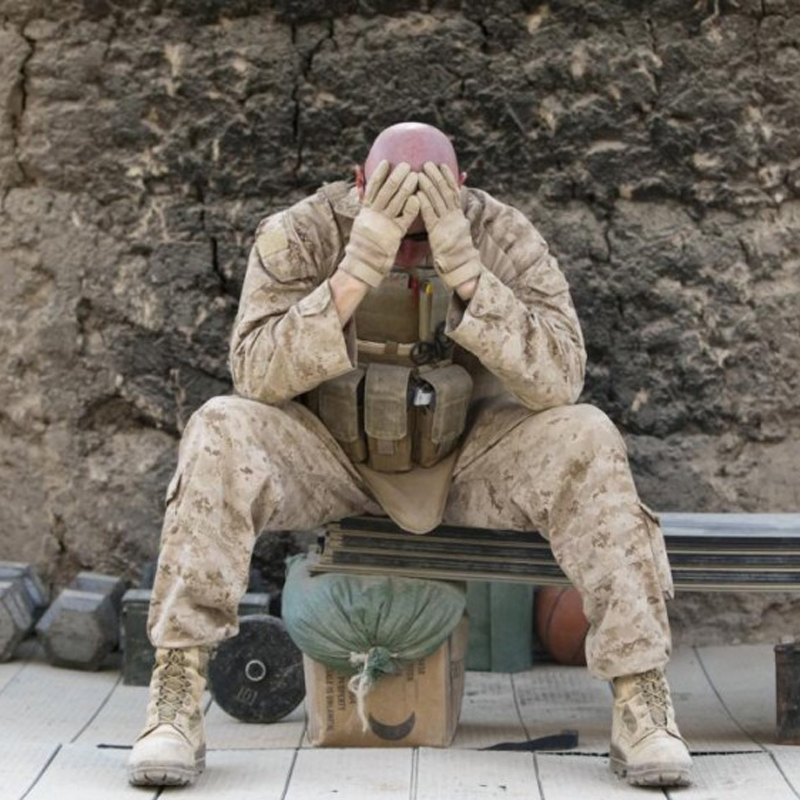 A soldier sitting with his head in his hands